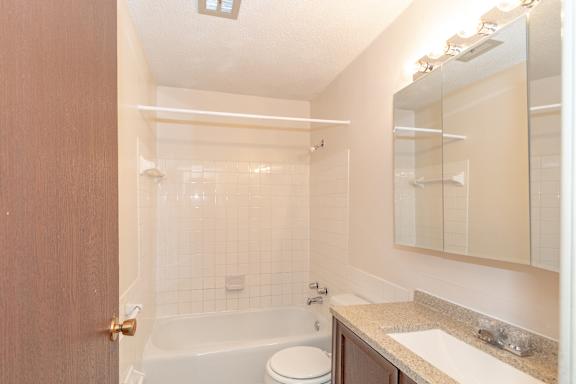 A bathroom with a toilet, sink, and bathtub.
