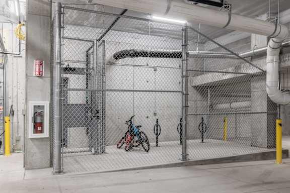 A bike is parked inside a chain-linked fenced area.
