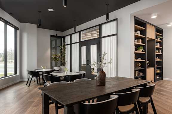 A modern dining room with a wooden table and chairs.