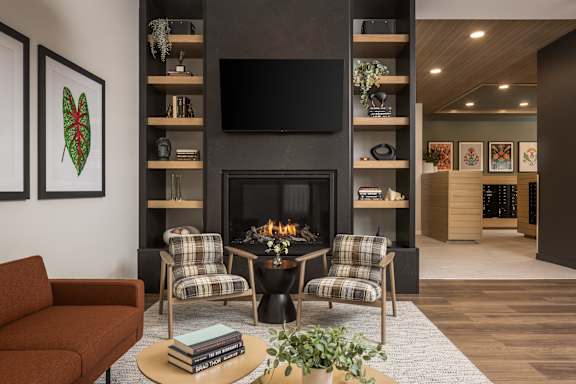 A living room with a fireplace and a television mounted above it.