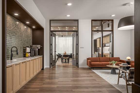 A modern kitchen with wooden floors and a dining area with a table and chairs.