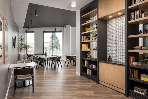 A modern dining room with a long table and chairs.