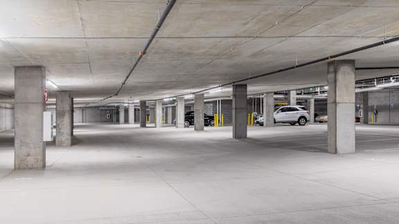 A parking garage with a white car parked in the middle.