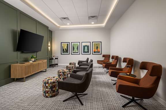 A row of brown chairs are lined up in a room.