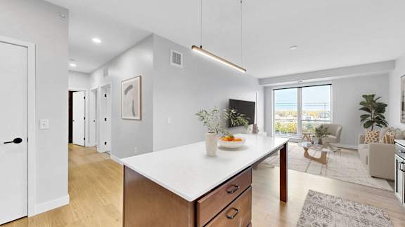 A modern kitchen with a large island and wooden cabinets.at The Rosalyn | Affordable 55+ Apartments in Bloomington, Bloominton, MN