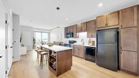 A modern kitchen with wooden cabinets and stainless steel appliances.at The Rosalyn | Affordable 55+ Apartments in Bloomington, Minnesota, 55420
