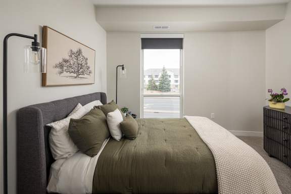 A bedroom with a large bed and a painting on the wall.