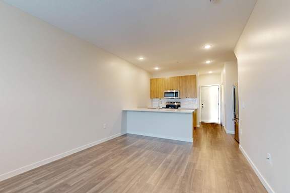 A long, empty hallway with a white counter on the left and a door on the right.