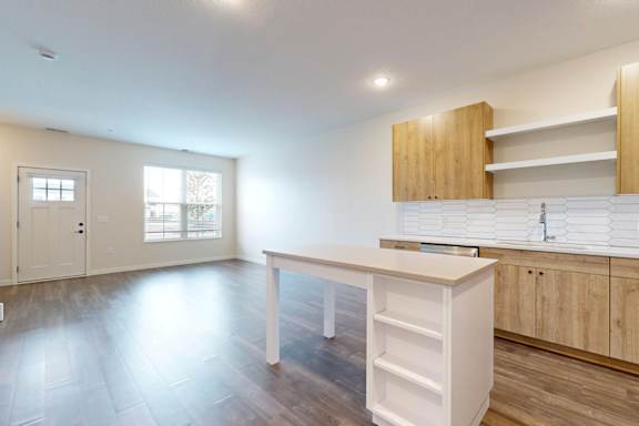 A kitchen with a white counter and wooden cabinets.