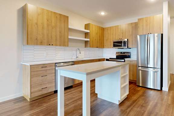A modern kitchen with wooden cabinets and stainless steel appliances.