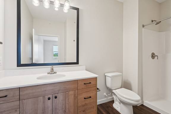 A bathroom with a white toilet, sink, and mirror.