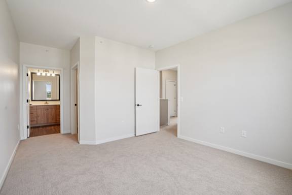 A large empty room with a doorway leading to another room.