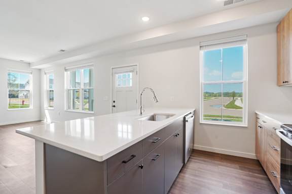 A modern kitchen with a large island and stainless steel appliances.