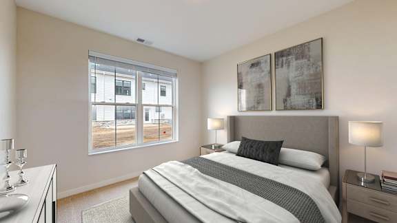 A bedroom with a large bed and two lamps.