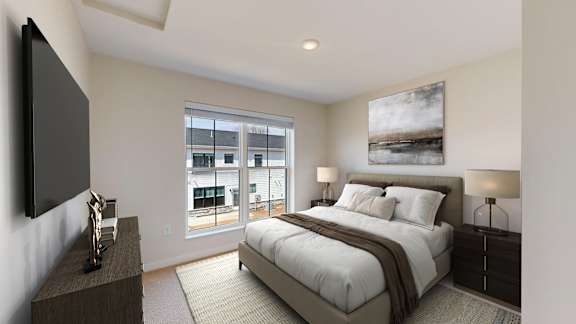 A bedroom with a large bed and a flat screen TV mounted on the wall.