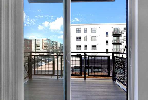 A balcony with a railing and a view of a building across the way.