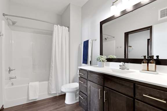 A bathroom with a white tub, sink, and toilet.