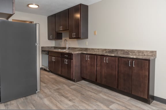 a kitchen with wooden cabinets and a stainless steel refrigerator