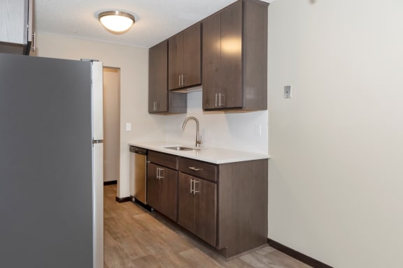 a kitchen with dark wood cabinets and a white counter top