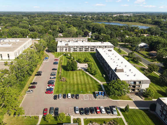 A parking lot with cars and a building in the background.