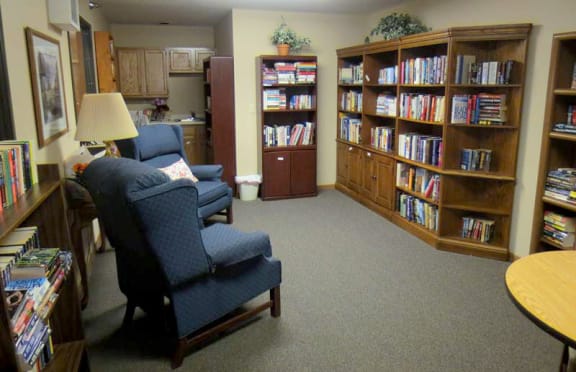 a living room filled with furniture and a bookcase  at Briarcliff Apartments, a 55+ Community, Mahtomedi, MN