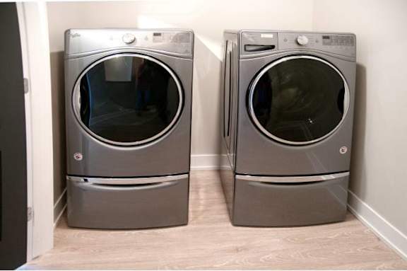 Two front load washing machines in a laundry room.