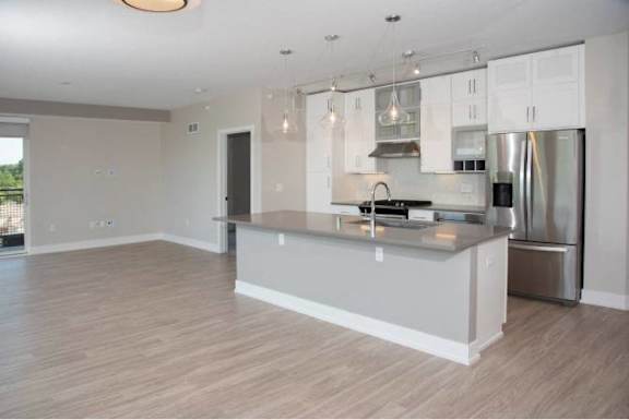 A modern kitchen with a large island and stainless steel appliances.