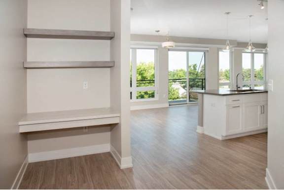A spacious kitchen with white cabinets and a large window.