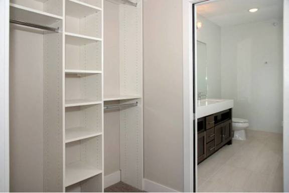 A white pantry with a mirror and a sink.
