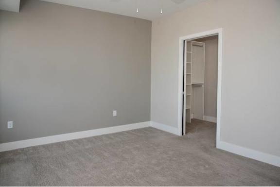 A room with a carpeted floor and a white door.