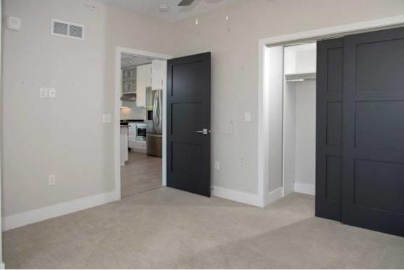 A black door is in a white room.