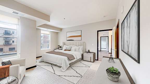 A bedroom with a large bed and a painting on the wall.