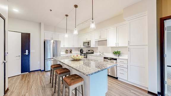 A kitchen with a blue island and white cabinets.