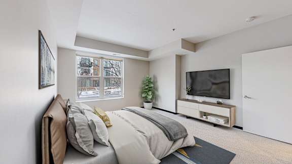 A bedroom with a large bed and a flat screen TV.