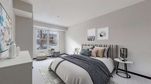 A bedroom with a large bed and a window overlooking a tree.