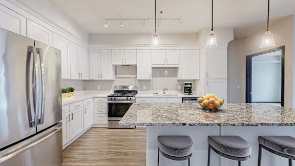 A kitchen with a granite countertop and stainless steel appliances.