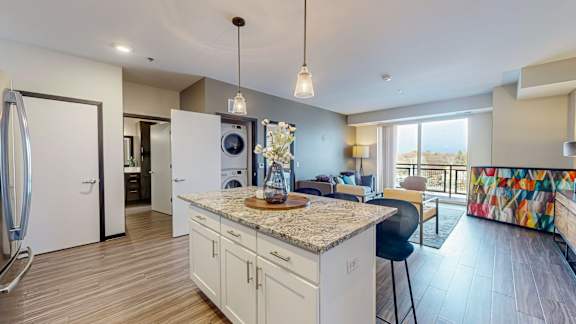 A kitchen with a marble countertop and a view of the outdoors.