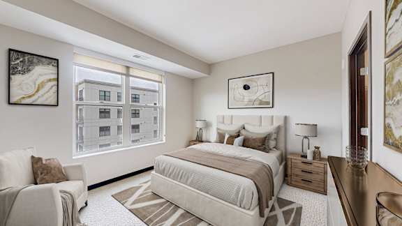 A bedroom with a large bed and a chair.