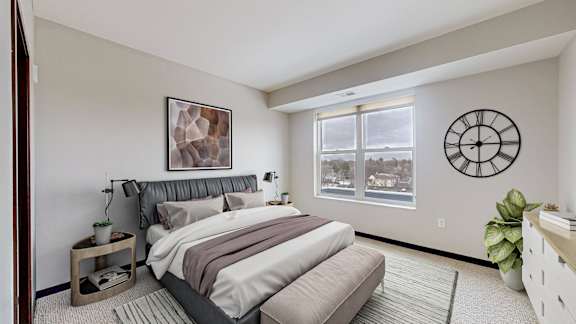 A bedroom with a large bed and a window overlooking a snowy landscape.