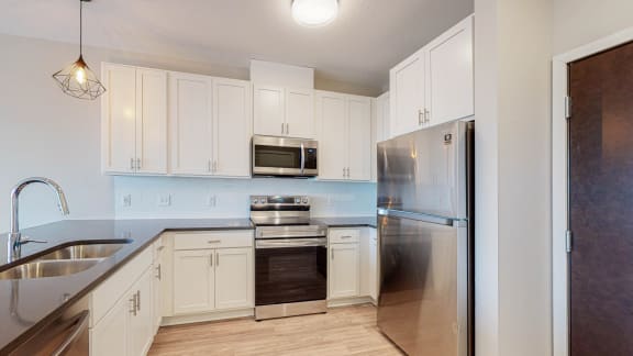 a kitchen with white cabinets and stainless steel appliances