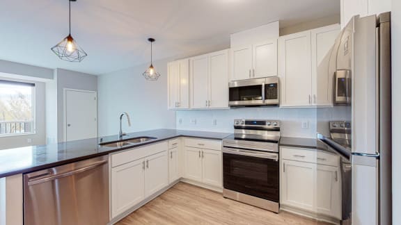 a kitchen with white cabinets and stainless steel appliances