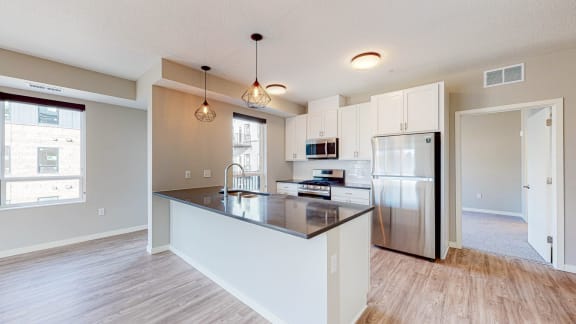 a kitchen with a large island and stainless steel appliances