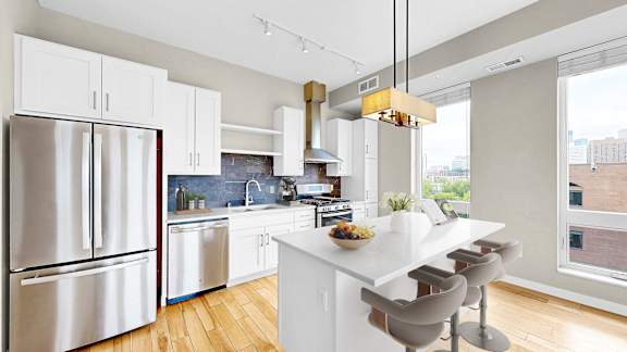 A modern kitchen with a white island and stainless steel appliances.