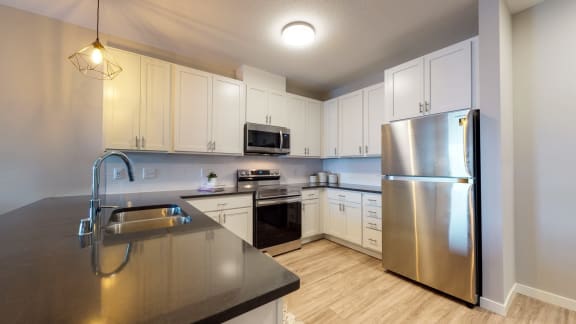a kitchen with white cabinets and stainless steel appliances