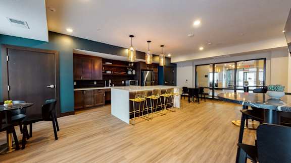 a kitchen and dining area with a large white island and yellow bar stools