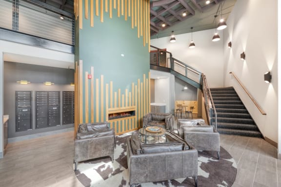 the lobby of a building with couches and a table and a fireplace
