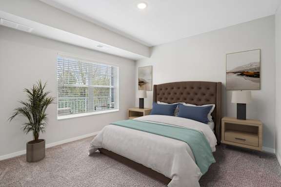 A bedroom with a large bed and a potted plant.