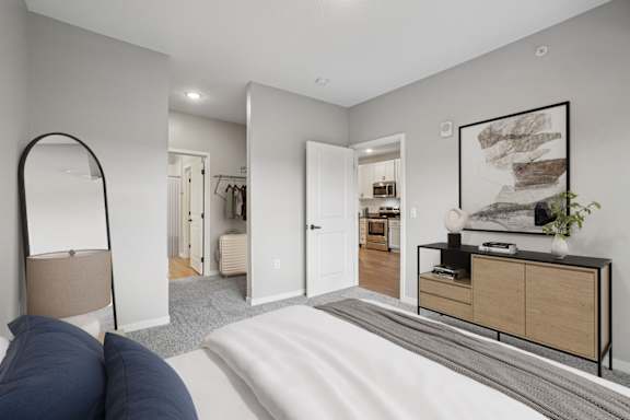 A bedroom with a large bed and a mirror on the wall.