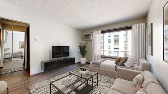 A modern living room with a flat screen TV and a glass coffee table.