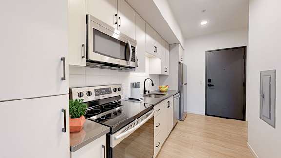 A modern kitchen with a stove, oven, microwave, and refrigerator.